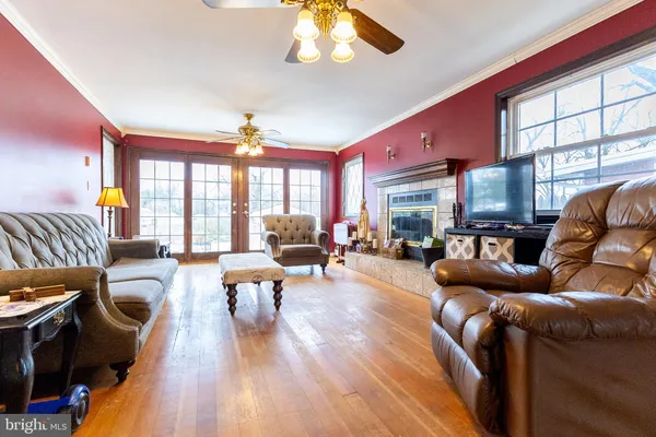 a living room with furniture a large window and wooden floor