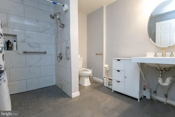 a bathroom with a sink a toilet and a mirror