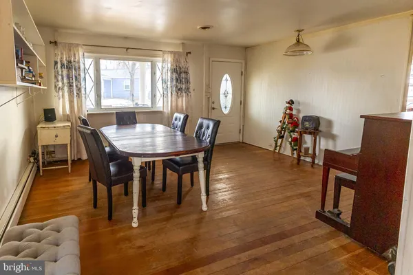 a view of a a dining room with furniture window and wooden floor