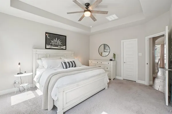 a spacious bedroom with a bed and a chandelier