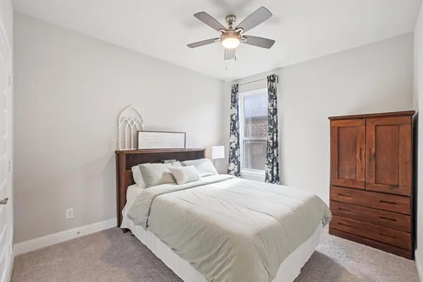 a bedroom with a large bed and a chandelier
