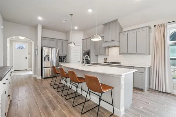 a kitchen with stainless steel appliances kitchen island granite countertop a refrigerator and a stove top oven