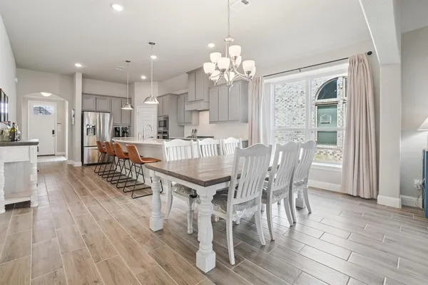 a view of a dining room with furniture a chandelier and wooden floor
