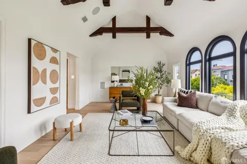 a living room with furniture a mirror and a window