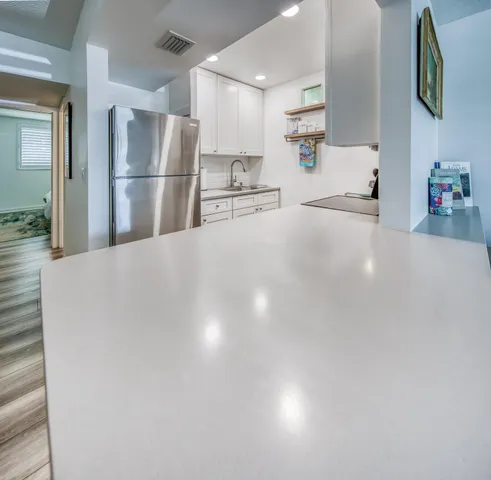 a view of a kitchen with refrigerator and cabinets