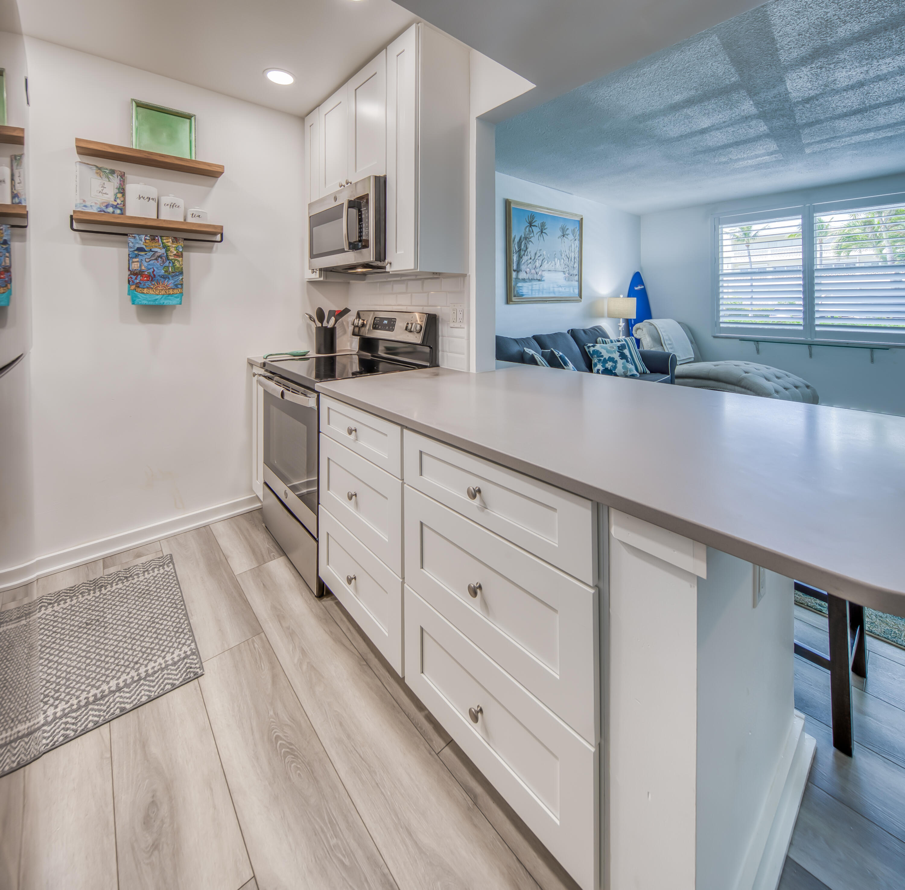 2565 South Ocean Boulevard, Unit 1040 (104) Palm Beach, FL 33480 - Photo 5 of 26 a kitchen with granite countertop white cabinets and white appliances