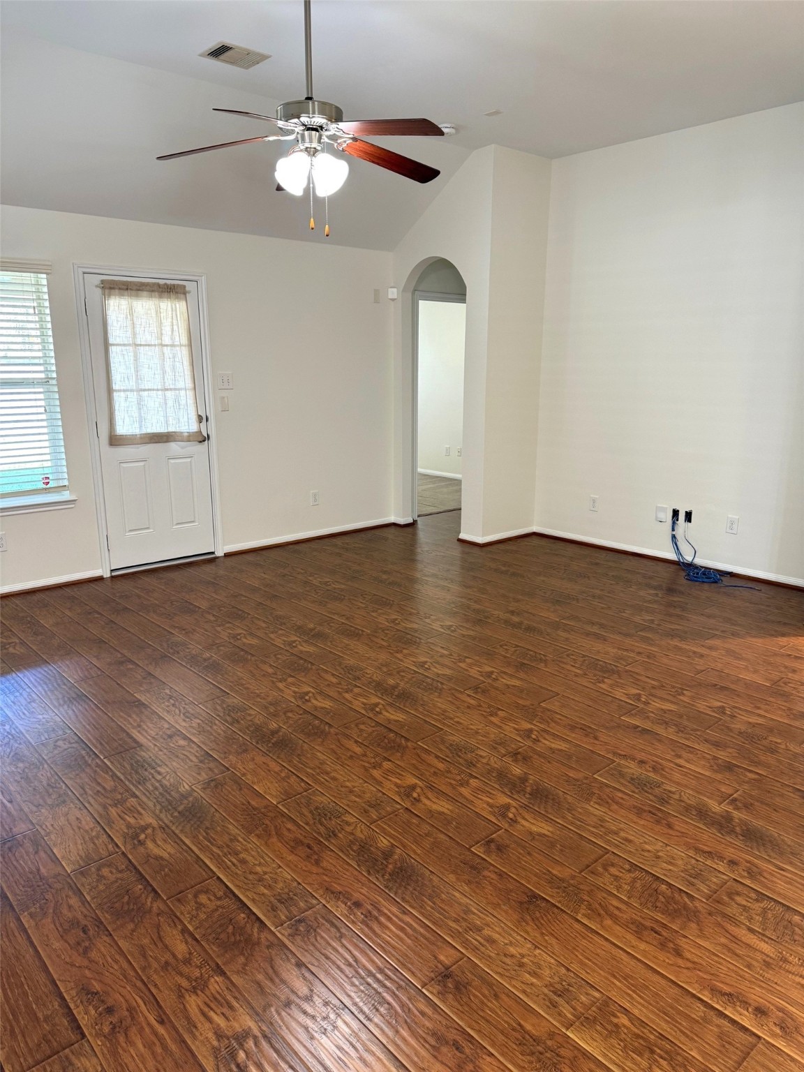 16818 Ranger Ridge Drive Cypress, TX 77429 - Photo 12 of 31 an empty room with wooden floor chandelier fan and windows