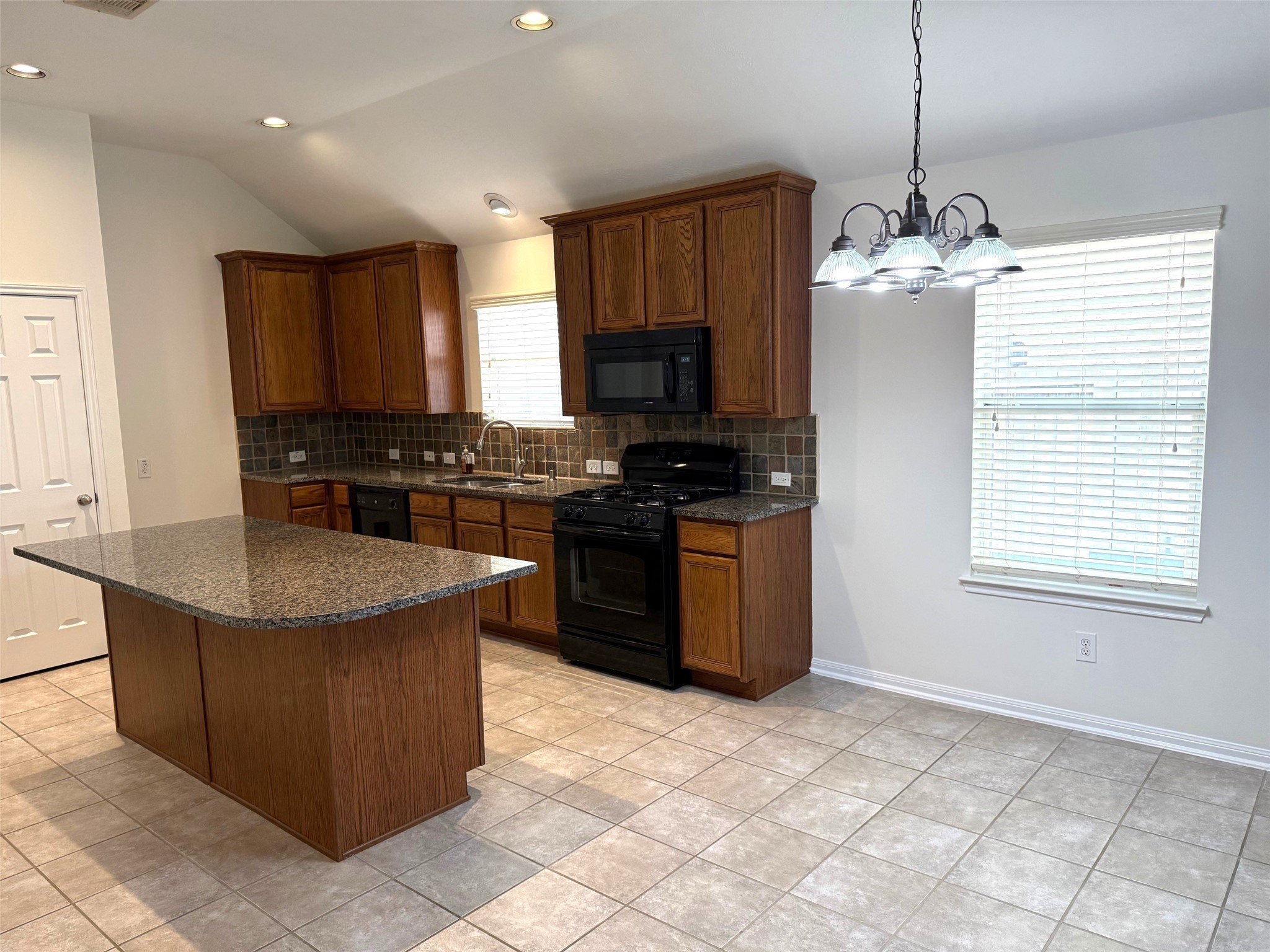 16818 Ranger Ridge Drive Cypress, TX 77429 - Photo 7 of 31 a kitchen with stainless steel appliances granite countertop a stove a sink a microwave and a refrigerator