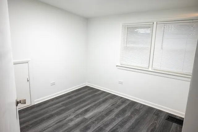 a view of a small space with wooden floor and a window