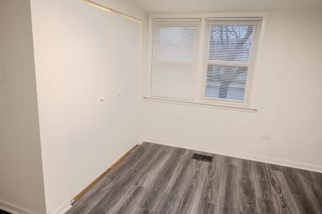 a view of a room with wooden floor and windows