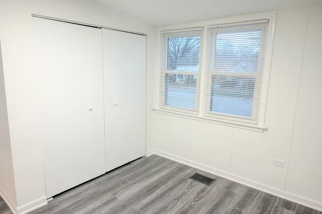 a view of a small space with wooden floor and a window