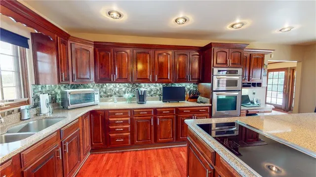 a kitchen with stainless steel appliances granite countertop a stove a sink and a refrigerator