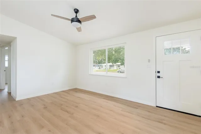 an empty room with fan and windows