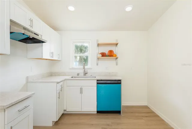a kitchen with a sink cabinets and window