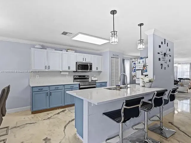 a kitchen with stainless steel appliances kitchen island granite countertop a sink a stove a dining table and chairs