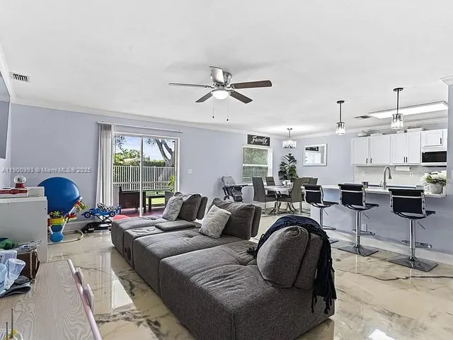 a living room with furniture a chandelier and a large window
