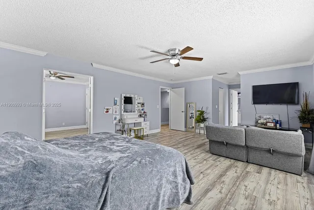 a spacious bedroom with a bed and a flat screen tv