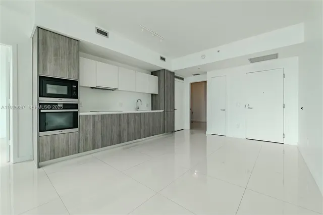 a view of kitchen with refrigerator and cabinets