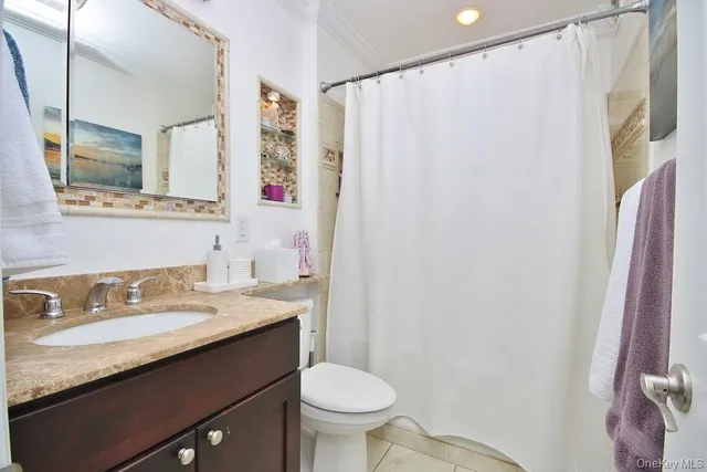 a bathroom with a granite countertop sink toilet and a mirror
