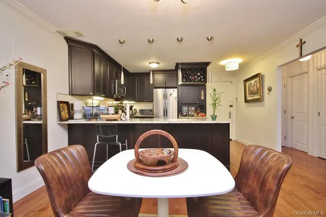 a kitchen with granite countertop a refrigerator a stove a sink a dining table and chairs