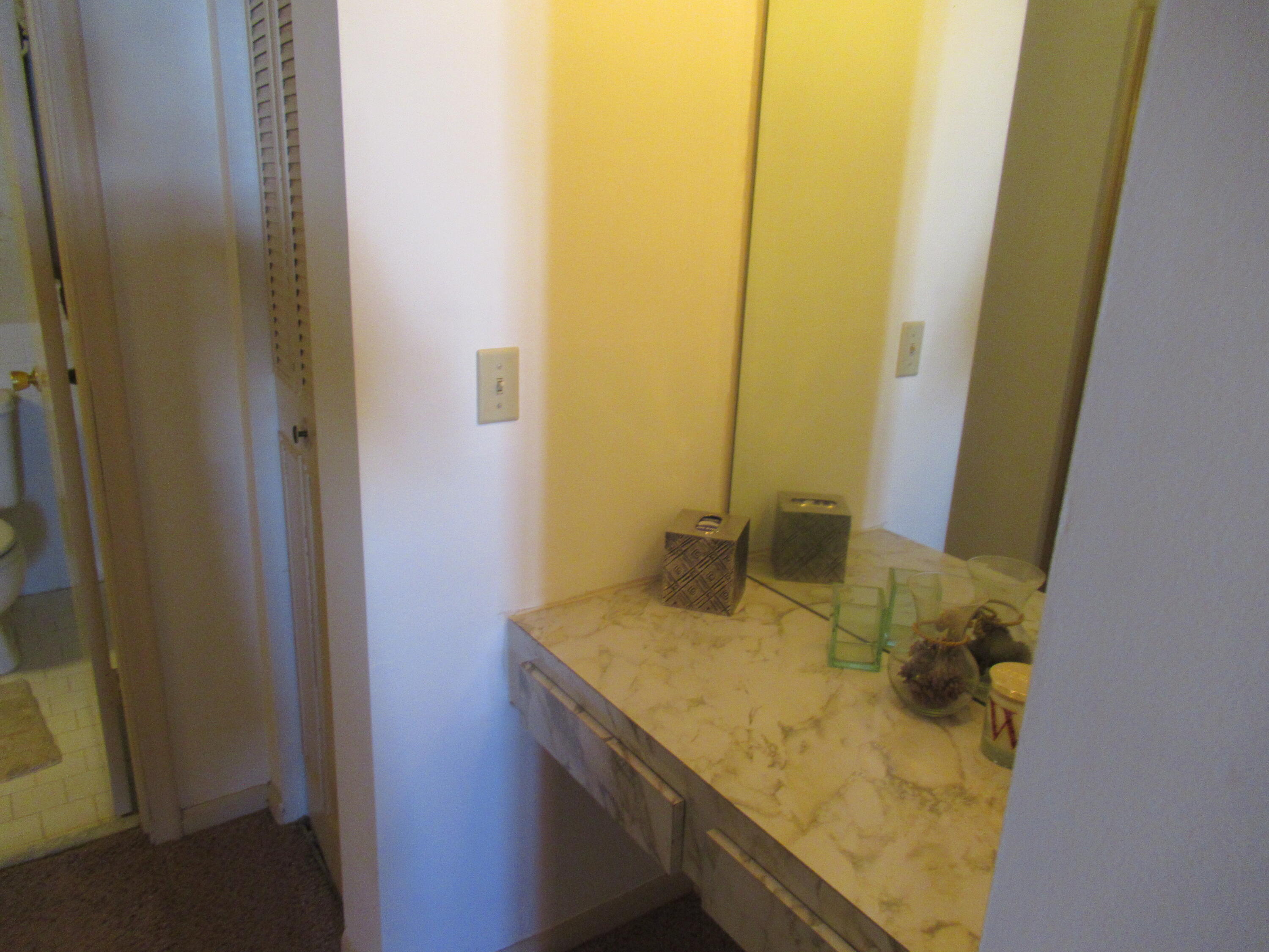22605 Southwest 66th Avenue, Unit 410 Boca Raton, FL 33428 - Photo 16 of 28 a bathroom with a granite countertop sink and a mirror