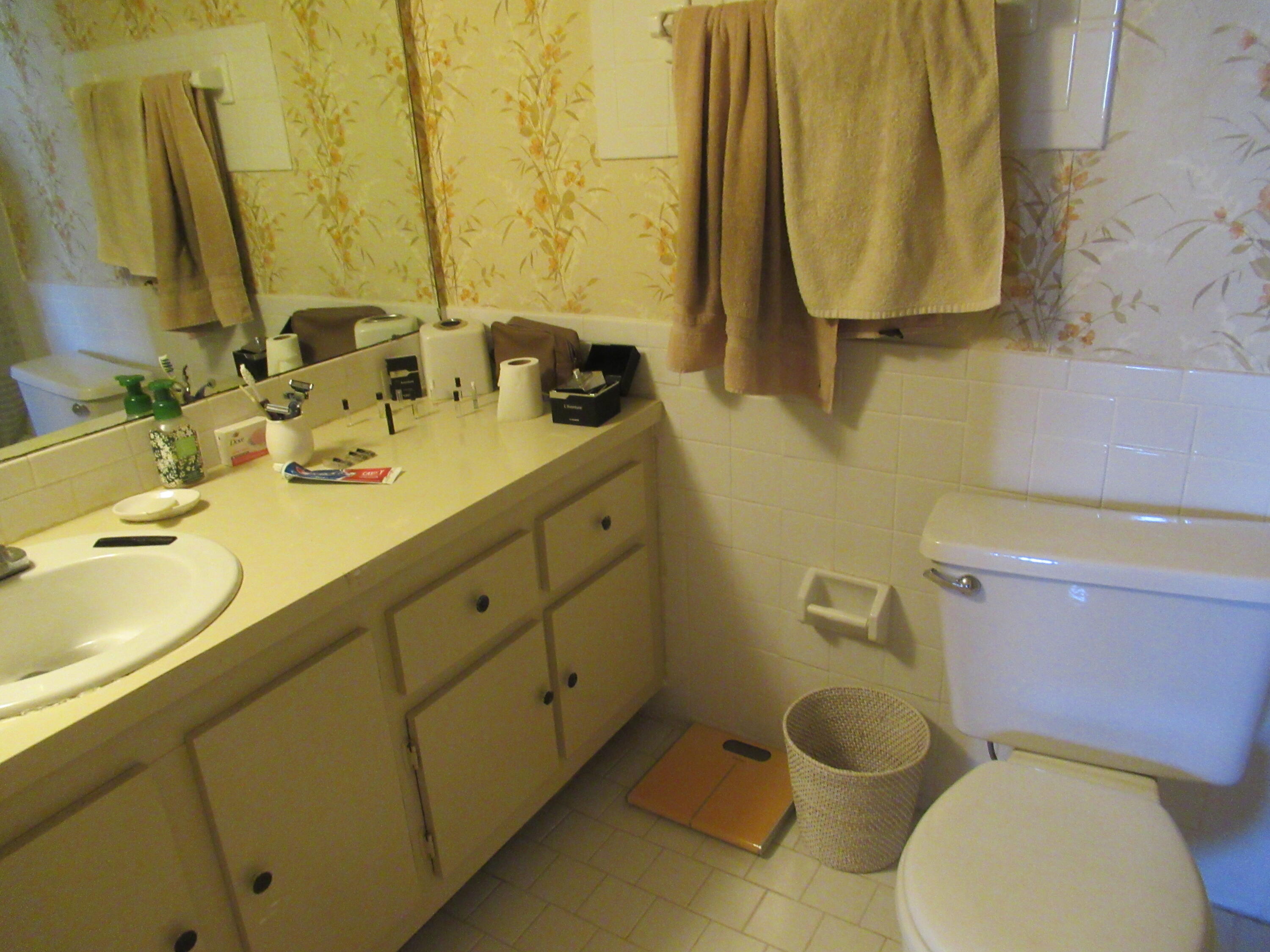 22605 Southwest 66th Avenue, Unit 410 Boca Raton, FL 33428 - Photo 17 of 28 a bathroom with a toilet sink and mirror