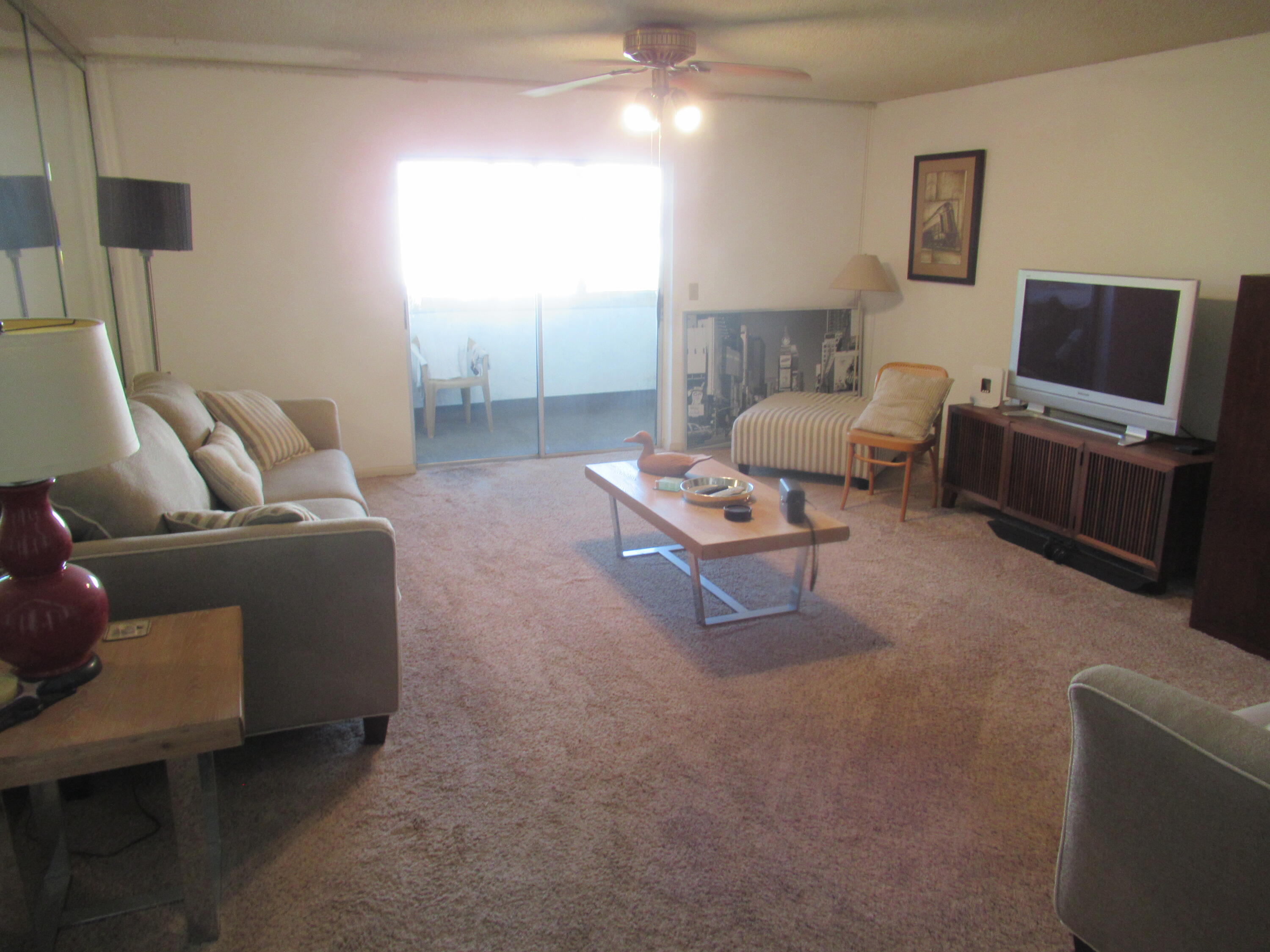 22605 Southwest 66th Avenue, Unit 410 Boca Raton, FL 33428 - Photo 3 of 28 a living room with furniture and a flat screen tv