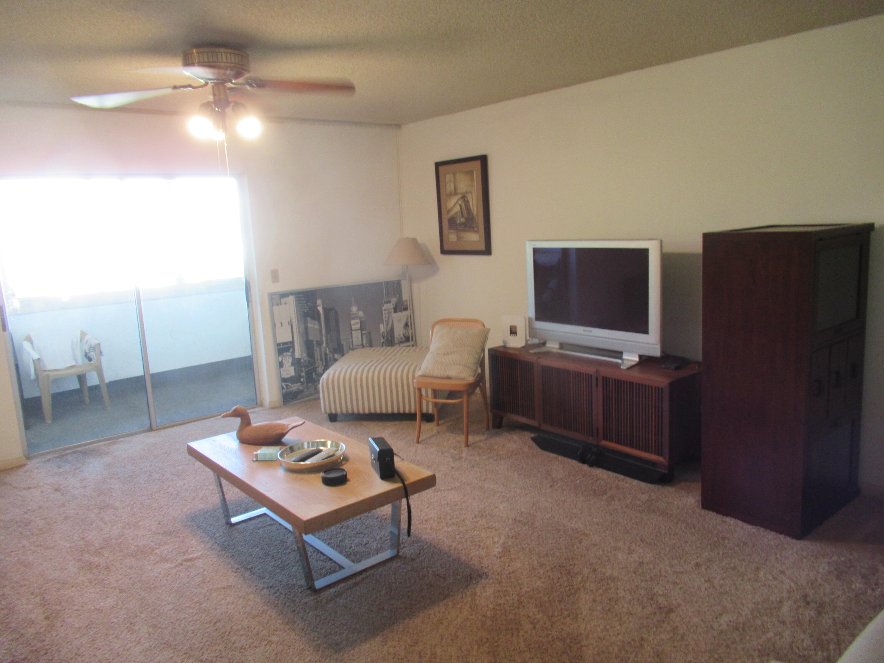 22605 Southwest 66th Avenue, Unit 410 Boca Raton, FL 33428 - Photo 5 of 28 a living room with furniture a rug and a flat screen tv