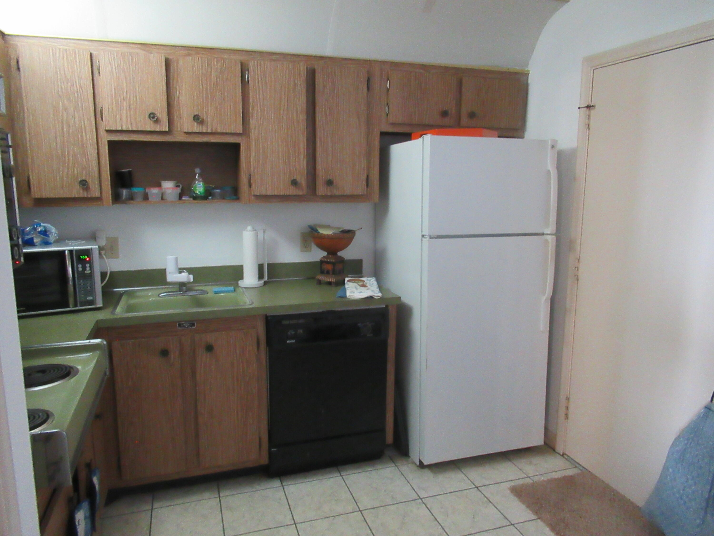 22605 Southwest 66th Avenue, Unit 410 Boca Raton, FL 33428 - Photo 7 of 28 a kitchen with a refrigerator and a stove top oven