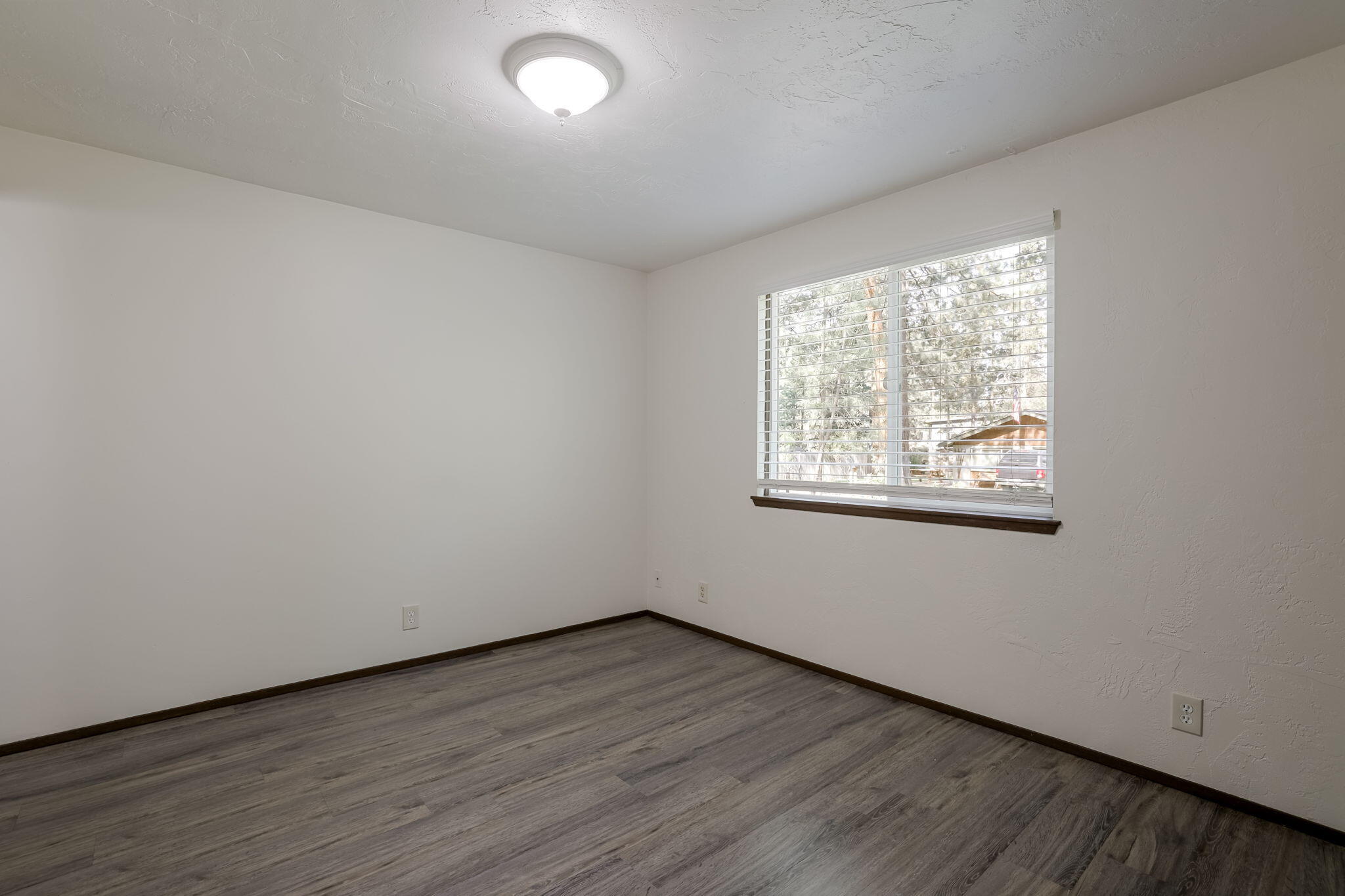 19968 Double Tree Court Bend, OR 97702 - Photo 14 of 28 an empty room with wooden floor and windows