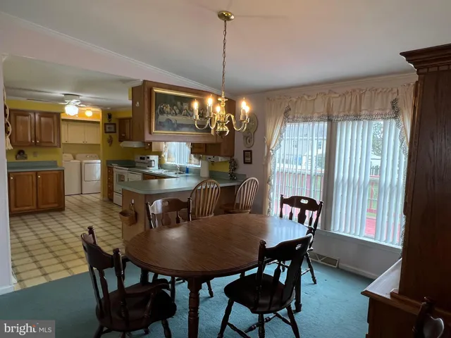 a dining room with furniture a chandelier and window