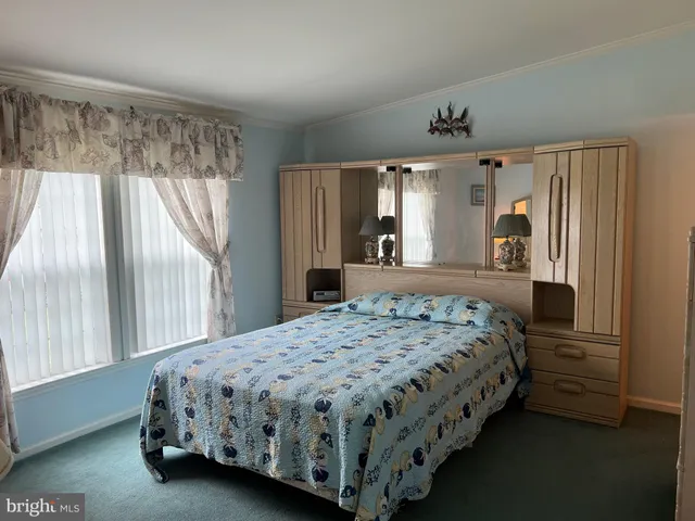 a bedroom with a bed chandelier and a window