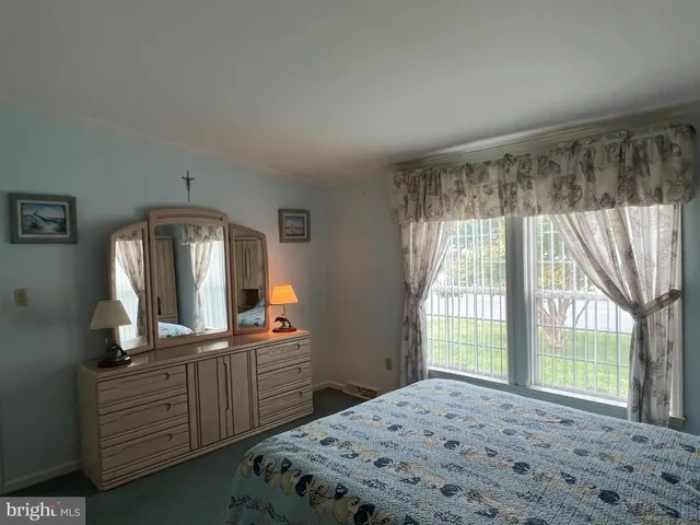 a bedroom with a bed and large windows