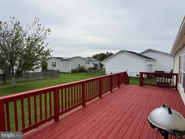 a view of a wooden deck and a backyard