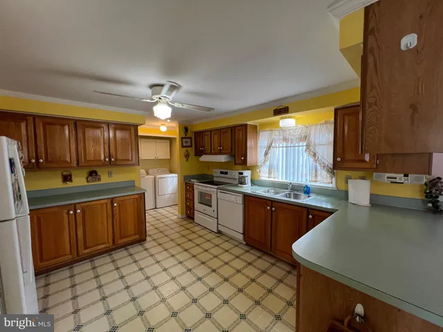 a kitchen with stainless steel appliances granite countertop a sink dishwasher stove and refrigerator with wooden cabinets