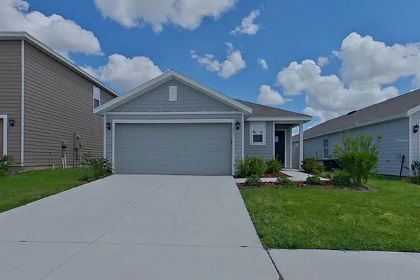 a front view of a house with a yard and garage