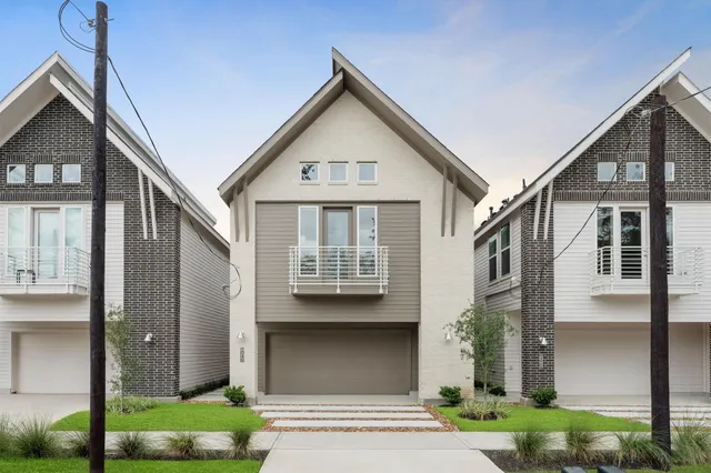 a front view of a house with a yard and potted plants