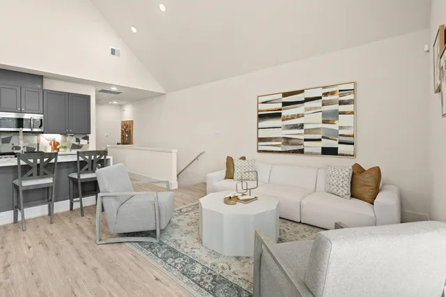 a kitchen with a dining table chairs and wooden floor