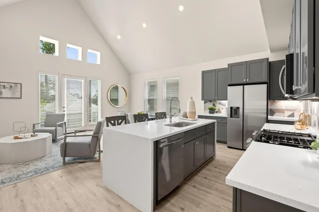 a kitchen with stainless steel appliances a sink a stove and a refrigerator