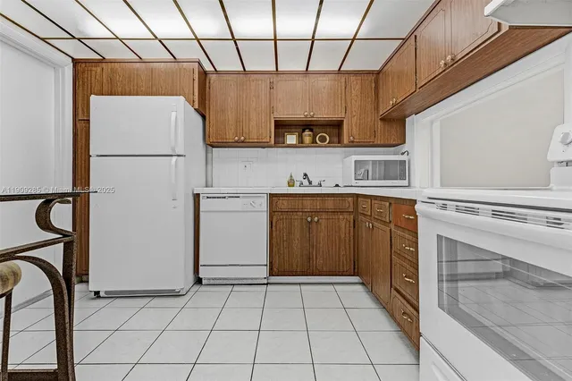 a kitchen with a sink a refrigerator and cabinets