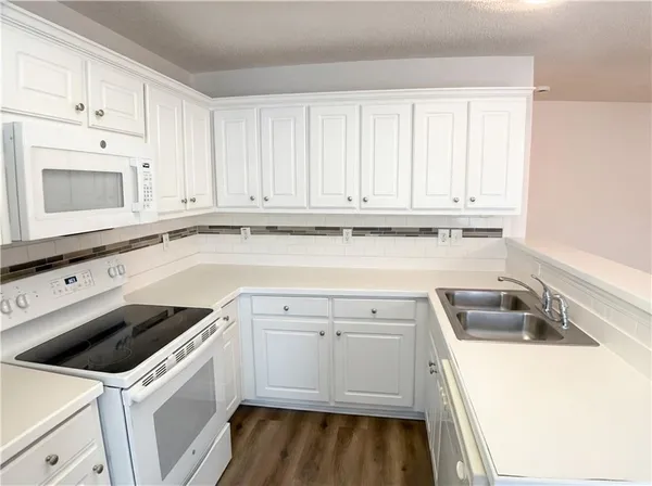 a view of a kitchen with sink and cabinets