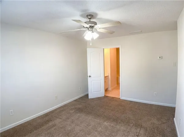 a view of a room with a ceiling fan and a fan