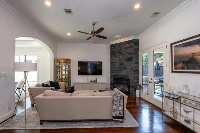 a living room with furniture a fireplace a flat screen tv and wooden floor