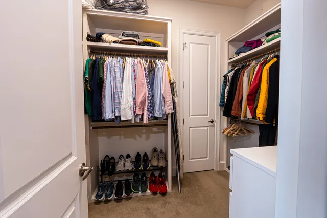 a view of walk in closet with clothes and shoes