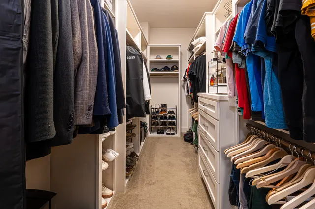 a view of walk in closet with clothes