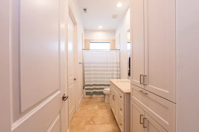 a bathroom with a sink a toilet and shower