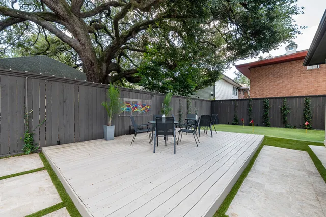 a view of backyard with table and chairs and wooden fence