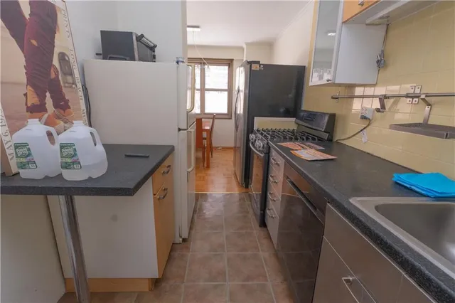 a kitchen with stainless steel appliances a stove a sink a refrigerator and wooden floor