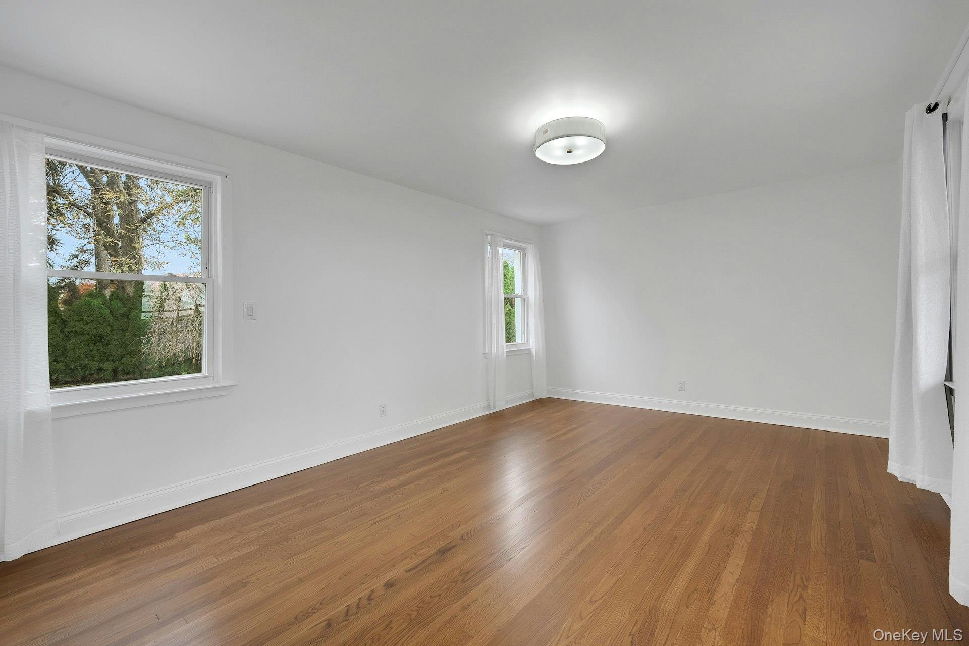 1 Echo Bay Place New Rochelle, NY 10805 - Photo 17 of 47 an empty room with wooden floor and windows