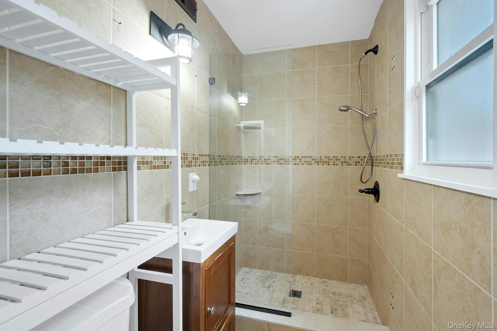 1 Echo Bay Place New Rochelle, NY 10805 - Photo 20 of 47 a bathroom with a sink a toilet a mirror and shower